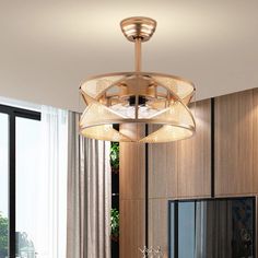 a modern chandelier hanging from the ceiling in a living room with wood paneling