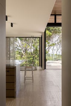 an open kitchen with white tile flooring next to a wooden table and stools