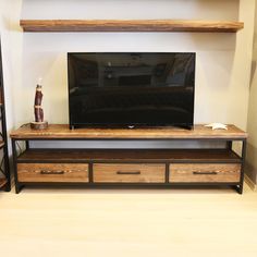 a flat screen tv sitting on top of a wooden entertainment center next to a shelf