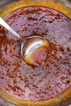 a spoon in a pot filled with sauce