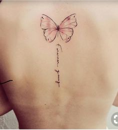 a woman's back with a butterfly tattoo on her left side ribcage