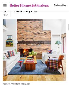 a living room filled with furniture and a fire place next to a brick wall in the background