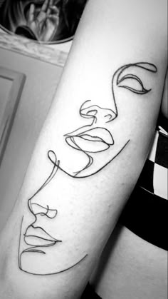 a woman's arm with a line drawing of a face on it, and the word