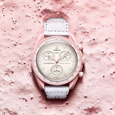 The Swatch X Omega Bioceramic Moonswatch Mission To Venus (So33p100) Features Pastel Pink Hues Contrasted With Beige And A White Velcro Strap, Reminiscent Of The Pastel Hues Prominent On The Surface Of Our Neighbor Venus. The Swatch X Omega Mission To Venus (So33p100) Features Pink Hours, Minutes, Second, And Counter Hands, And Swatch Calls The Diamond-Like Details On The Edges A "Touch Of Feminine Elegance." The Watch, Like The Others In The Collection, Also Features Quartz Movement And Is 3 Ba Moon Swatch, Mission To Mercury, Swatch Store, Omega X Swatch, Logo Elements, Omega Speedmaster Moonwatch, Moon Watch, Black Backdrop, Couple Watch