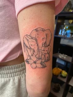 an elephant and calf tattoo on the arm