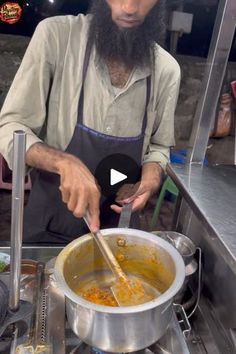 a man in an apron stirring food into a pot