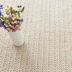 a vase filled with flowers sitting on top of a rug