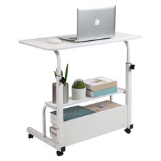 a laptop computer sitting on top of a white shelf next to a potted plant