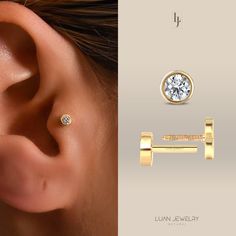 an ear piercing with a diamond in the middle and a gold bar to the side