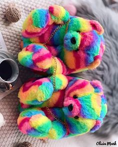 two rainbow colored teddy bears on a blanket next to a camera