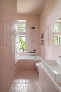 a bathroom with pink tiles on the walls and floor