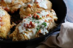 a skillet filled with chicken and cheese covered in sauce