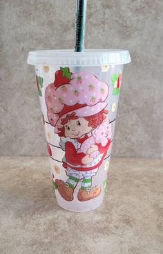 a plastic cup with a straw in the shape of a girl holding a doughnut