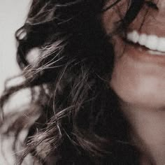 a close up of a woman's face with white teeth