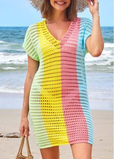 a woman is standing on the beach wearing a colorful crochet dress and hat