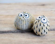 two ceramic figurines sitting on top of a wooden table