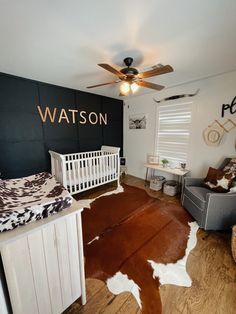 a baby's room with a cow skin rug on the floor and a white crib