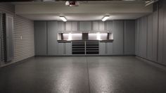 an empty storage room with lights on the ceiling and cabinets in the back ground area