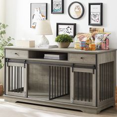 an entertainment center with pictures on the wall and a dog crate in front of it