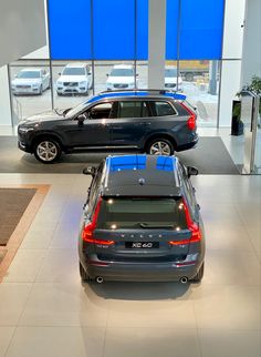 two cars are parked in a showroom next to each other