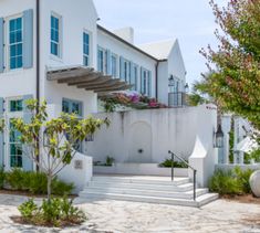 a white house with blue windows and stairs