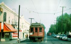 an old red trolley car traveling down the street