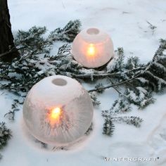 two snow covered candles are sitting in the snow