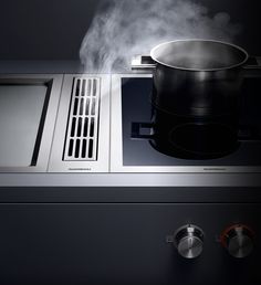 steam coming out of the top of a stove with a pot on it's burner