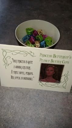 a bowl filled with green and purple candies next to a sign that says princess buttercups