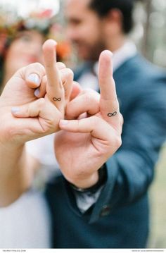 a man and woman making the v sign with their fingers in front of each other