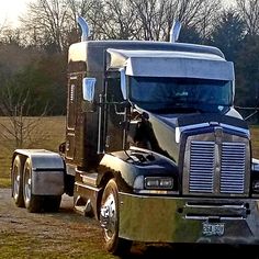 a large semi truck is parked in the grass