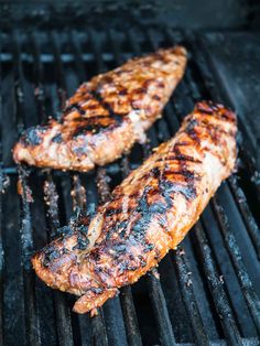 two pieces of meat cooking on a grill