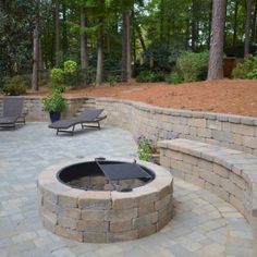 an outdoor fire pit surrounded by seating and trees