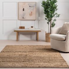 a living room with a chair, coffee table and potted plant