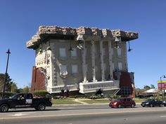 a large building with many windows on the side of it's face next to some cars