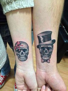 two people with matching tattoos on their arms, one is wearing a top hat and the other has a bow tie