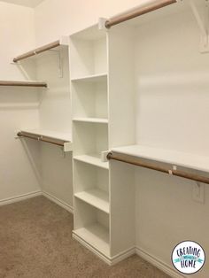 an empty walk in closet with white shelving and wooden shelves on the wall, along with carpeted flooring