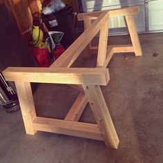 two wooden benches sitting next to each other on the floor in front of a garage