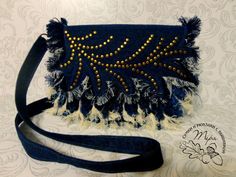 a blue purse with gold beads and tassels