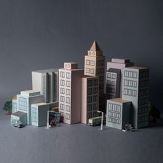 a group of toy buildings sitting on top of a gray table next to each other