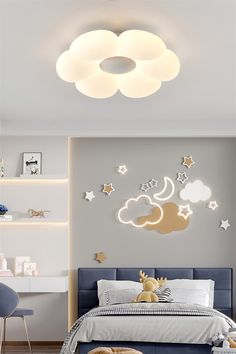 a child's bedroom decorated in white and blue with stars, clouds, and moon lights