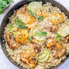 chicken and rice in a skillet with limes on the side