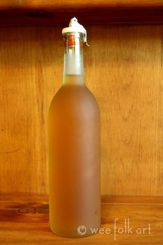 a bottle of liquid sitting on top of a wooden shelf