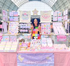 a woman standing in front of a table with lots of greeting cards and decorations on it