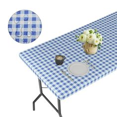 a blue and white checkered table cloth with flowers in a vase on it next to a plate