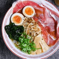 a bowl filled with meat and eggs on top of a table