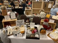 there are many knitted items on display at this market stall, including hats and mittens