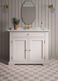 a bathroom vanity with a mirror and potted plant