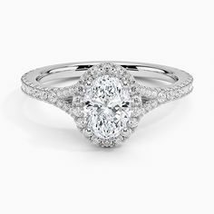 an oval shaped diamond ring with halos on the sides