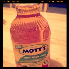 a bottle of mott's apple juice sitting on top of a wooden table